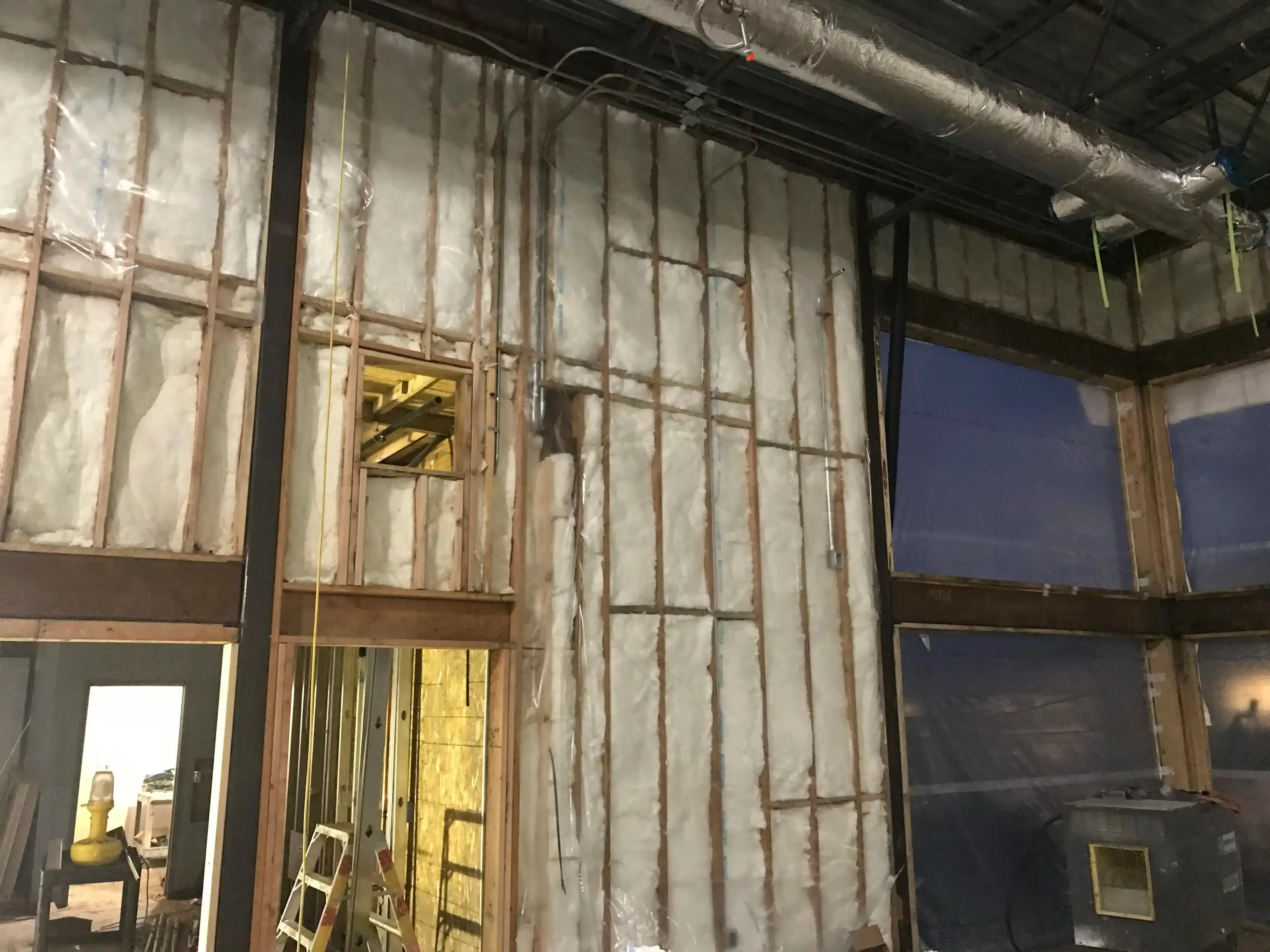 Photo of insulation and rough-in work getting compelted inside the new 'commons' space.