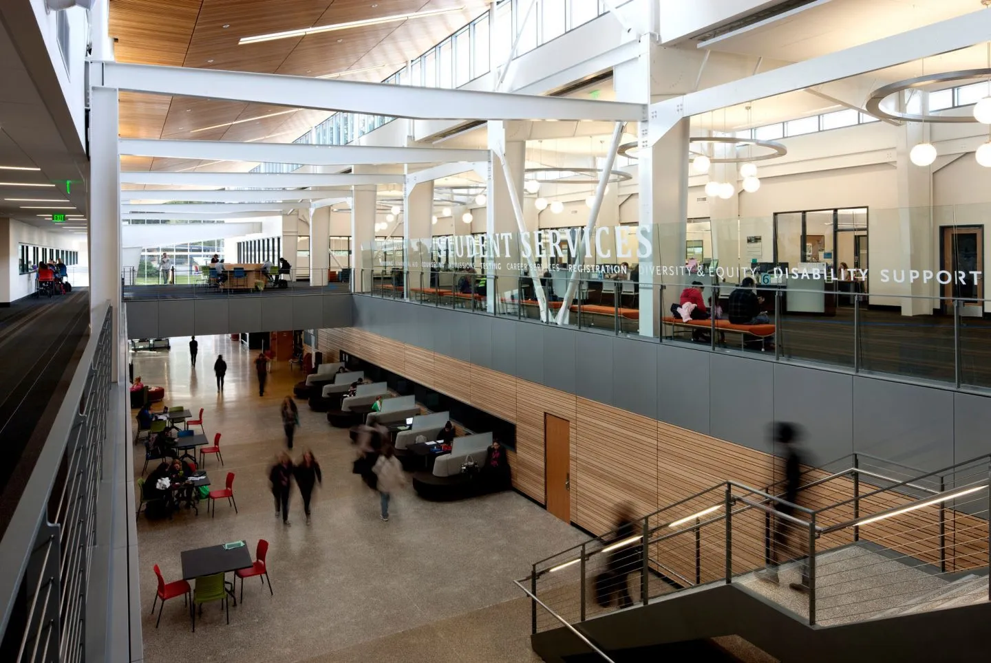 Photo from the second floor, different angle, and featuring text on solid-glass railing that reads: 'Student Services'.