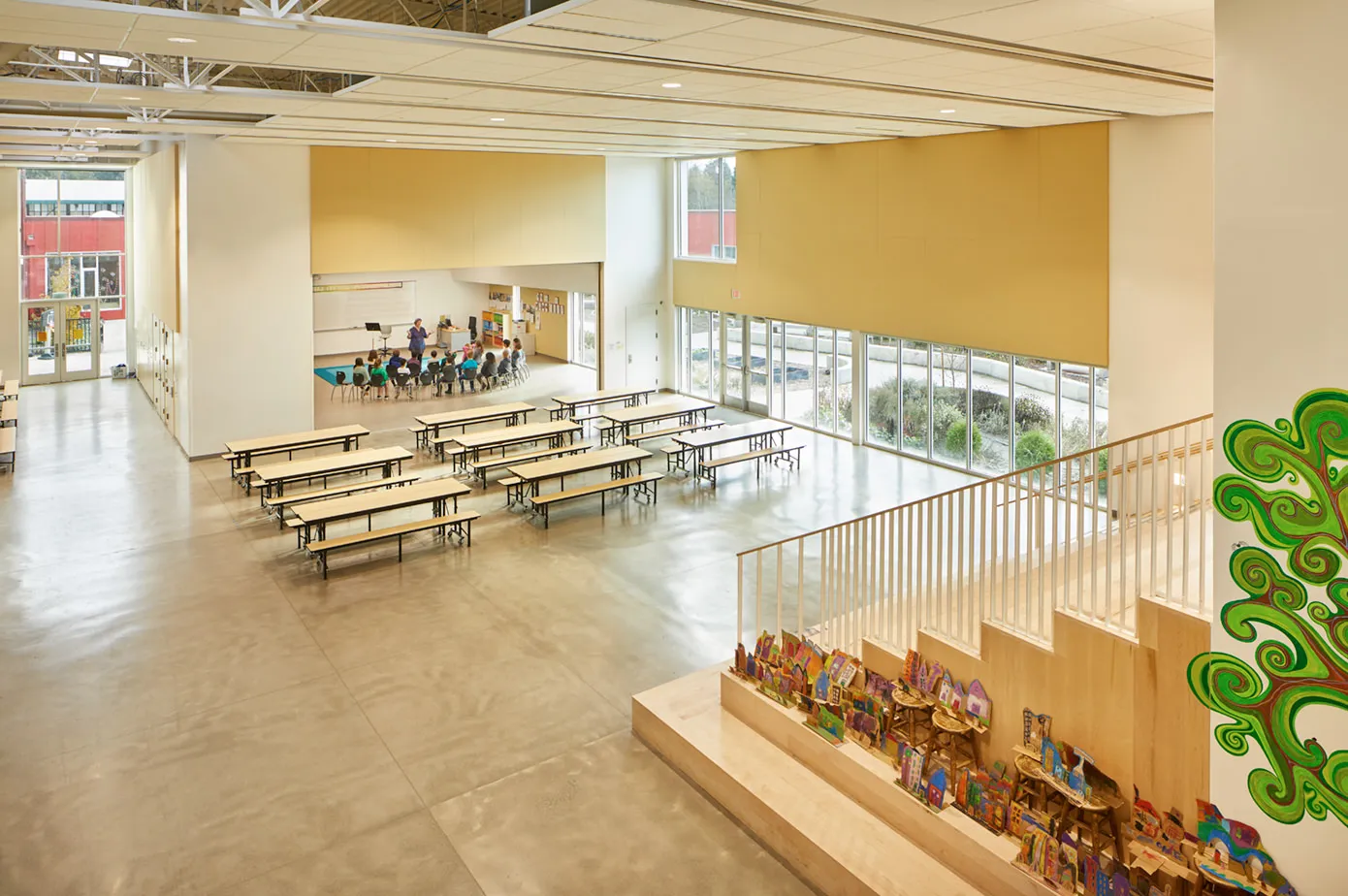 Photo of one of the commons spaces with an open partition wall exposing a music room.