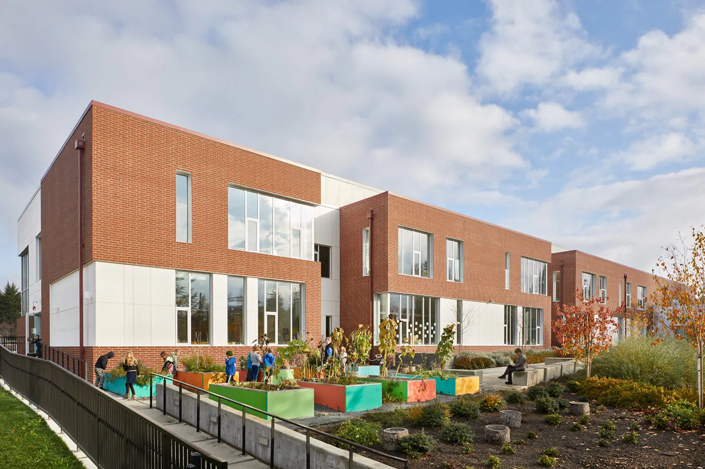 Photo taken from the Southwest featuring the outdoor garden with students surrounding the planters.