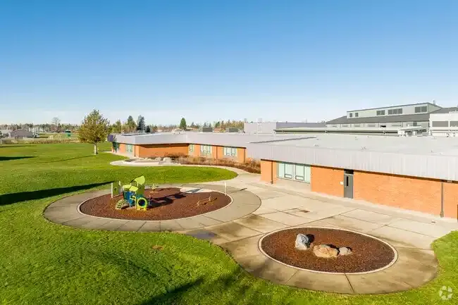 Photo of the new play structure with the school in the background. 