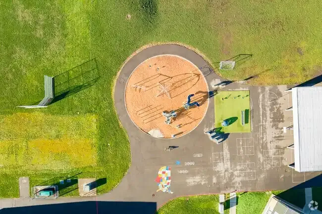 Photo of the new play structure with the school in the background. 
