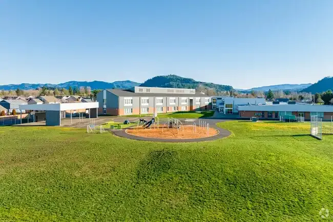 Photo of the new play structure with the school in the background. 